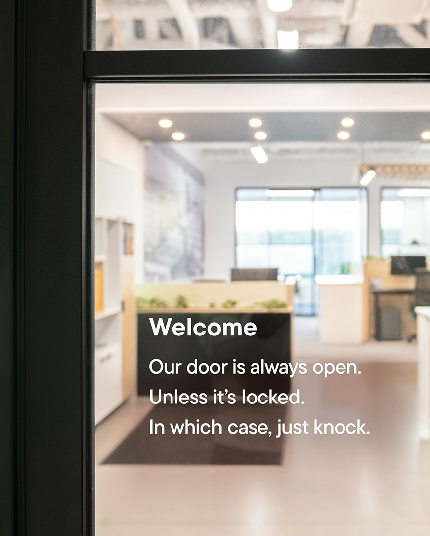 Close-up look at welcoming copy written on an office door